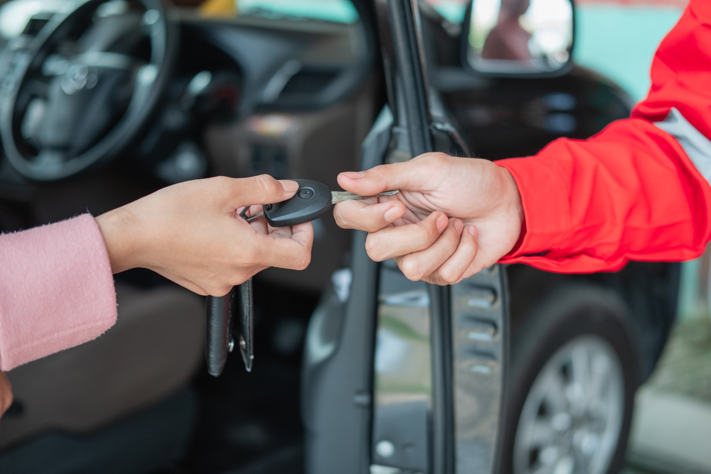 Close up of Customer Hand Giving Car Keys to Mechanic